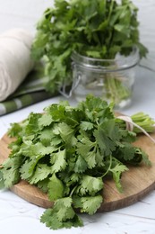 Photo of Fresh aromatic cilantro on white table, closeup