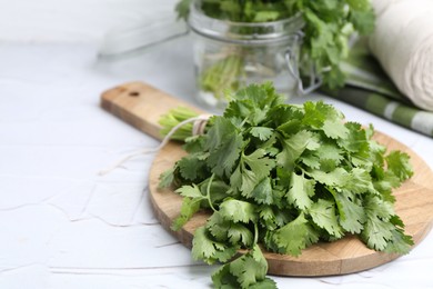 Photo of Fresh aromatic cilantro on white table, closeup. Space for text