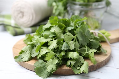 Photo of Fresh aromatic cilantro on white table, closeup
