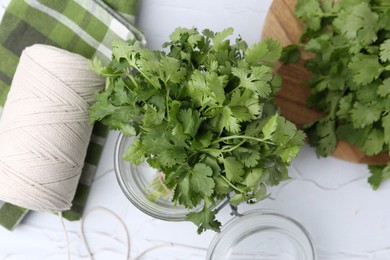 Photo of Fresh aromatic cilantro in jar on white table, flat lay