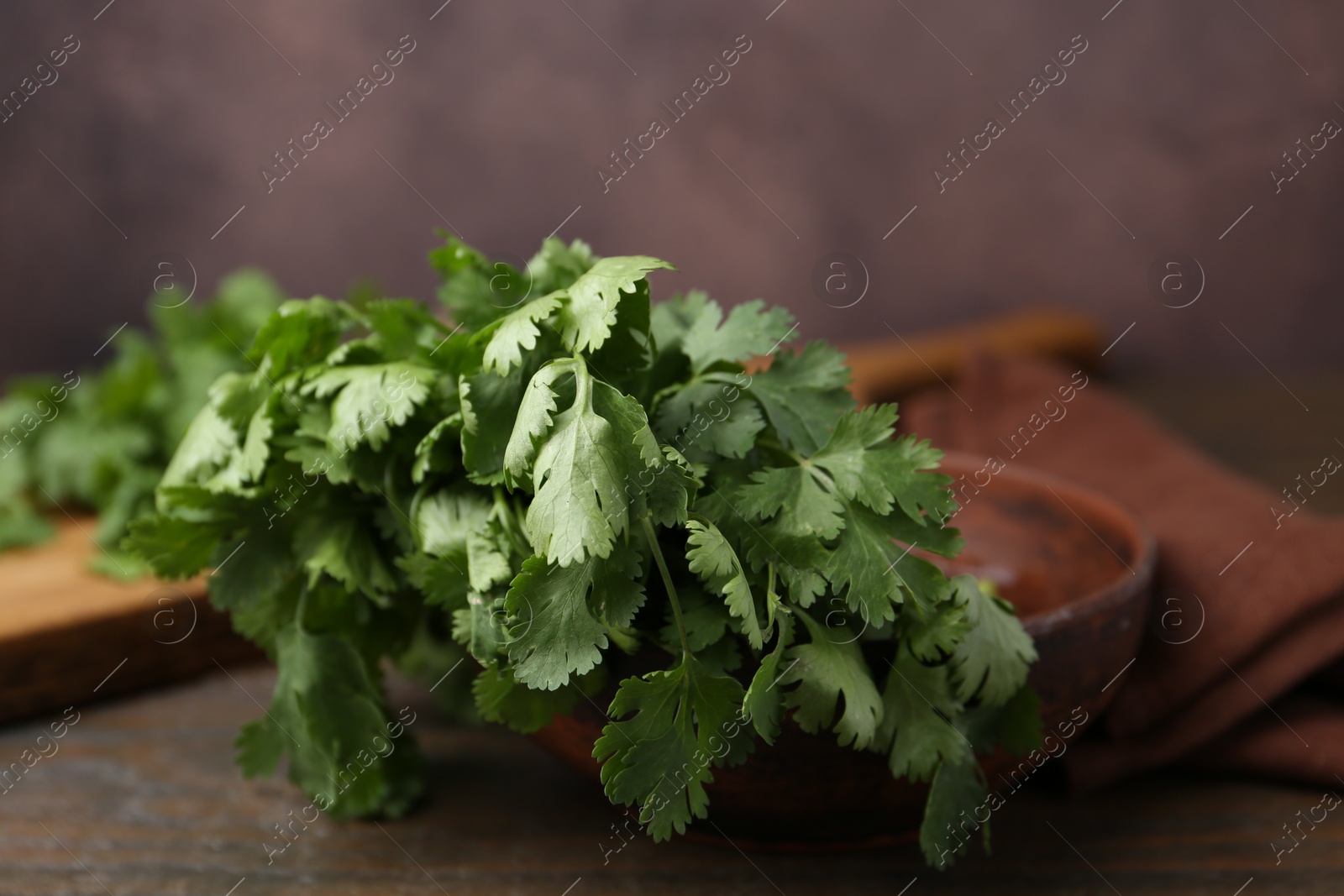 Photo of Fresh aromatic cilantro on wooden table, closeup