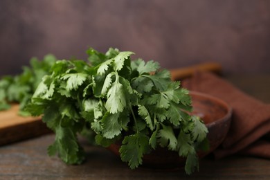Photo of Fresh aromatic cilantro on wooden table, closeup