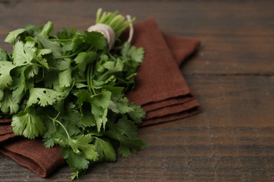 Photo of Fresh aromatic cilantro on wooden table, closeup. Space for text
