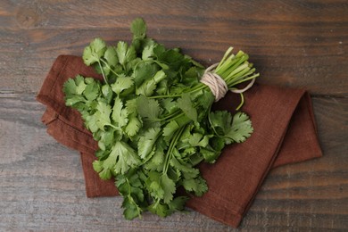 Photo of Fresh aromatic cilantro on wooden table, top view