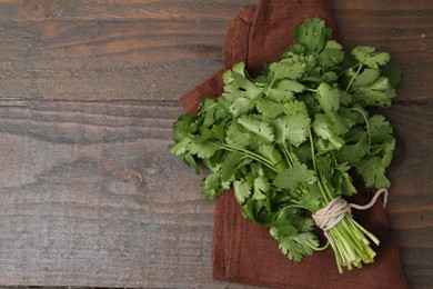 Photo of Fresh aromatic cilantro on wooden table, top view. Space for text