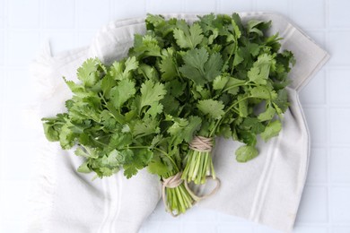 Photo of Fresh aromatic cilantro on white tiled table, top view
