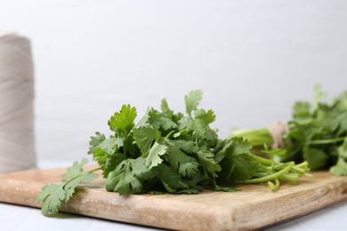 Photo of Fresh aromatic cilantro on white table, closeup. Space for text