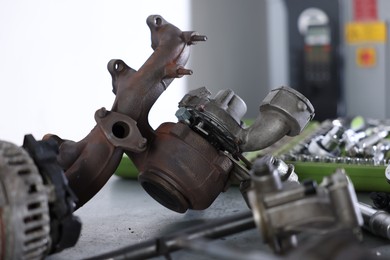 Photo of Different auto parts on grey table indoors, closeup