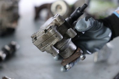 Photo of Auto part. Professional mechanic with power steering pump indoors, closeup