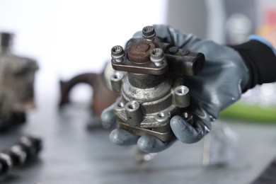 Photo of Auto part. Professional mechanic with power steering pump indoors, closeup. Space for text