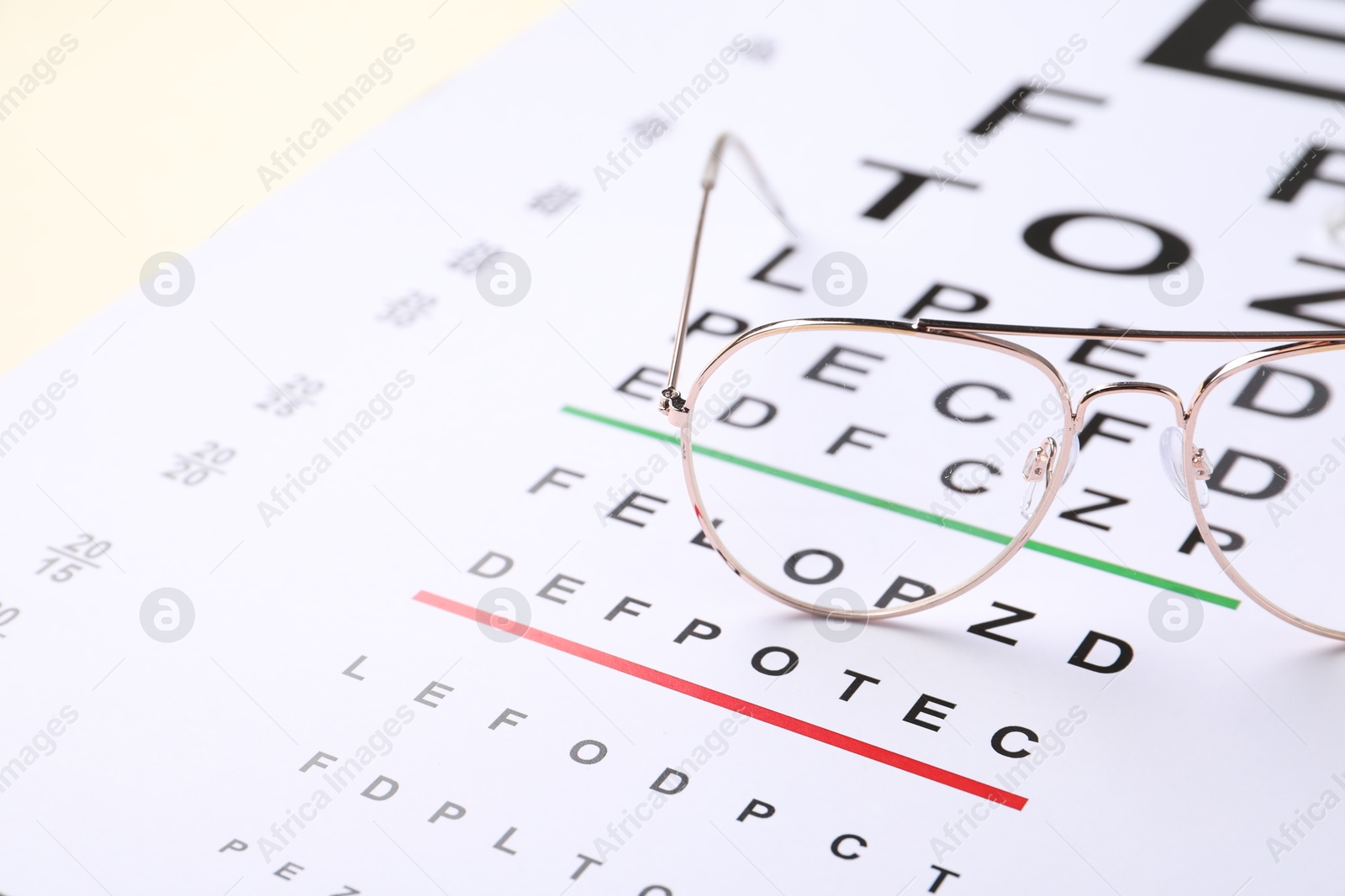Vision test chart and glasses on beige background, closeup. Space for text Photo of Vision test chart and glasses on beige background, closeup. Space for text