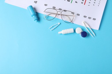 Photo of Vision test chart, glasses, tweezers, lenses and bottles of medical drops on light blue background, flat lay. Space for text