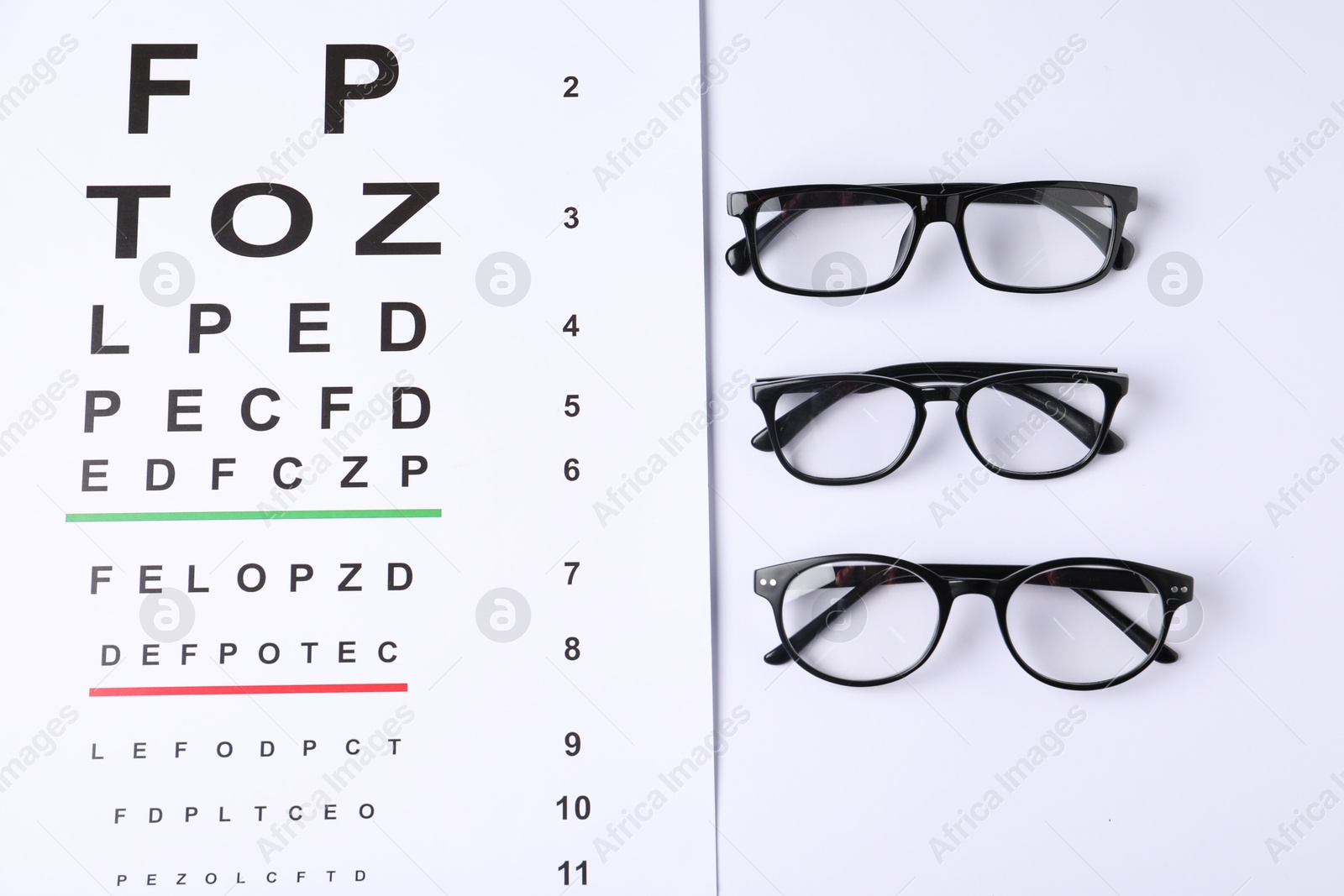 Vision test chart and glasses on white background, flat lay Photo of Vision test chart and glasses on white background, flat lay