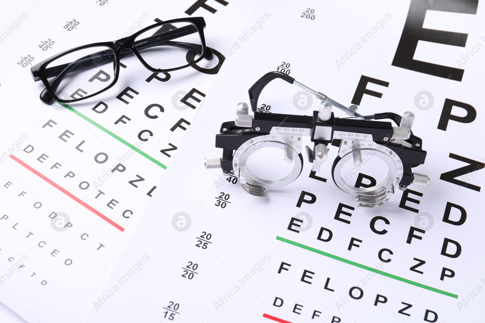 Glasses and trial frame on vision test charts, above view Photo of Glasses and trial frame on vision test charts, above view