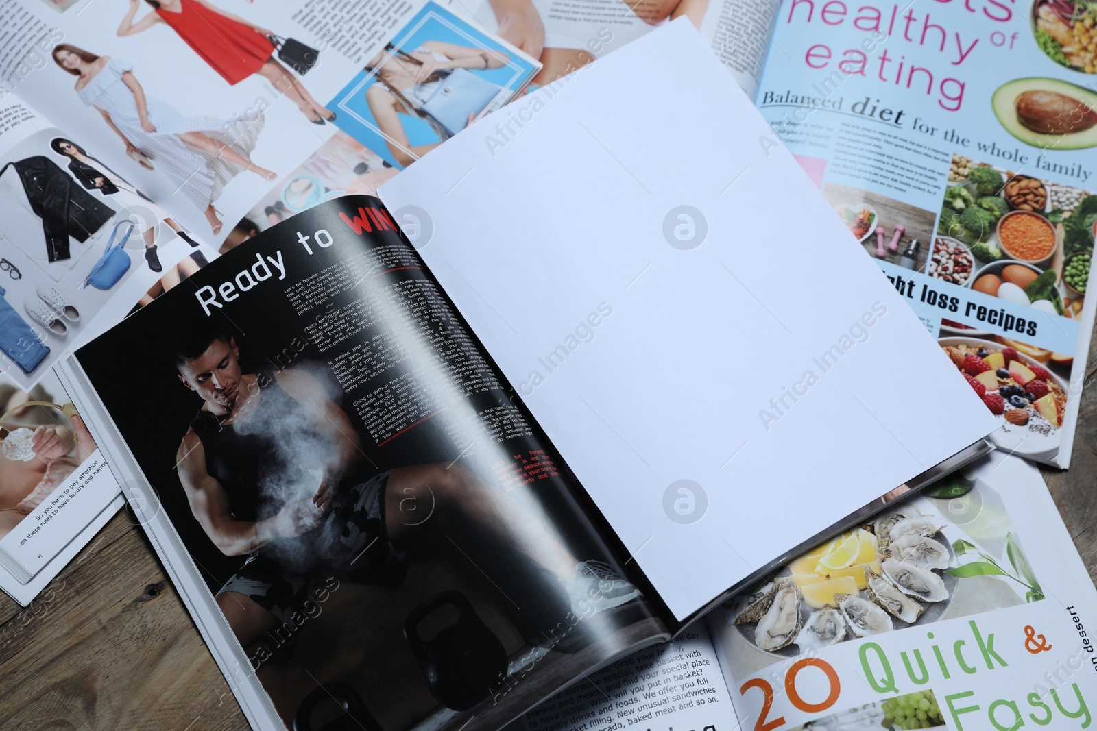 Different trendy magazines on wooden table, closeup Photo of Different trendy magazines on wooden table, closeup