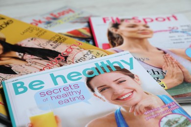 Photo of Different trendy magazines on white table, closeup