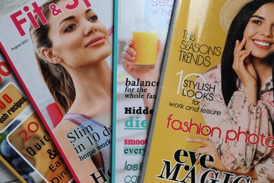 Photo of Many different trendy magazines as background, closeup