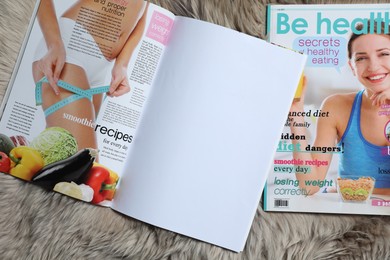 Photo of Trendy magazines on faux fur, top view. Mockup for design