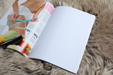 Photo of Open magazine on faux fur, closeup. Mockup for design