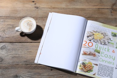 Photo of Open magazine and coffee on wooden background. Mockup for design
