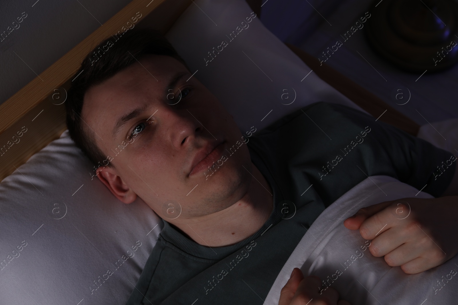 Frustrated man suffering from insomnia in bed indoors, top view Photo of Frustrated man suffering from insomnia in bed indoors, top view