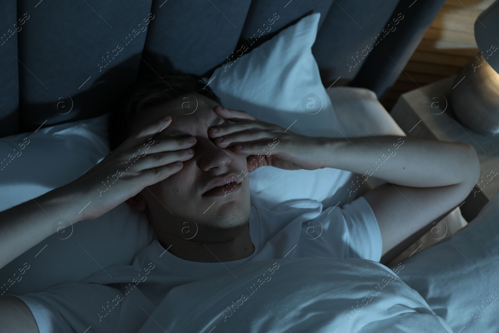 Photo of Frustrated man suffering from insomnia in bed indoors, above view