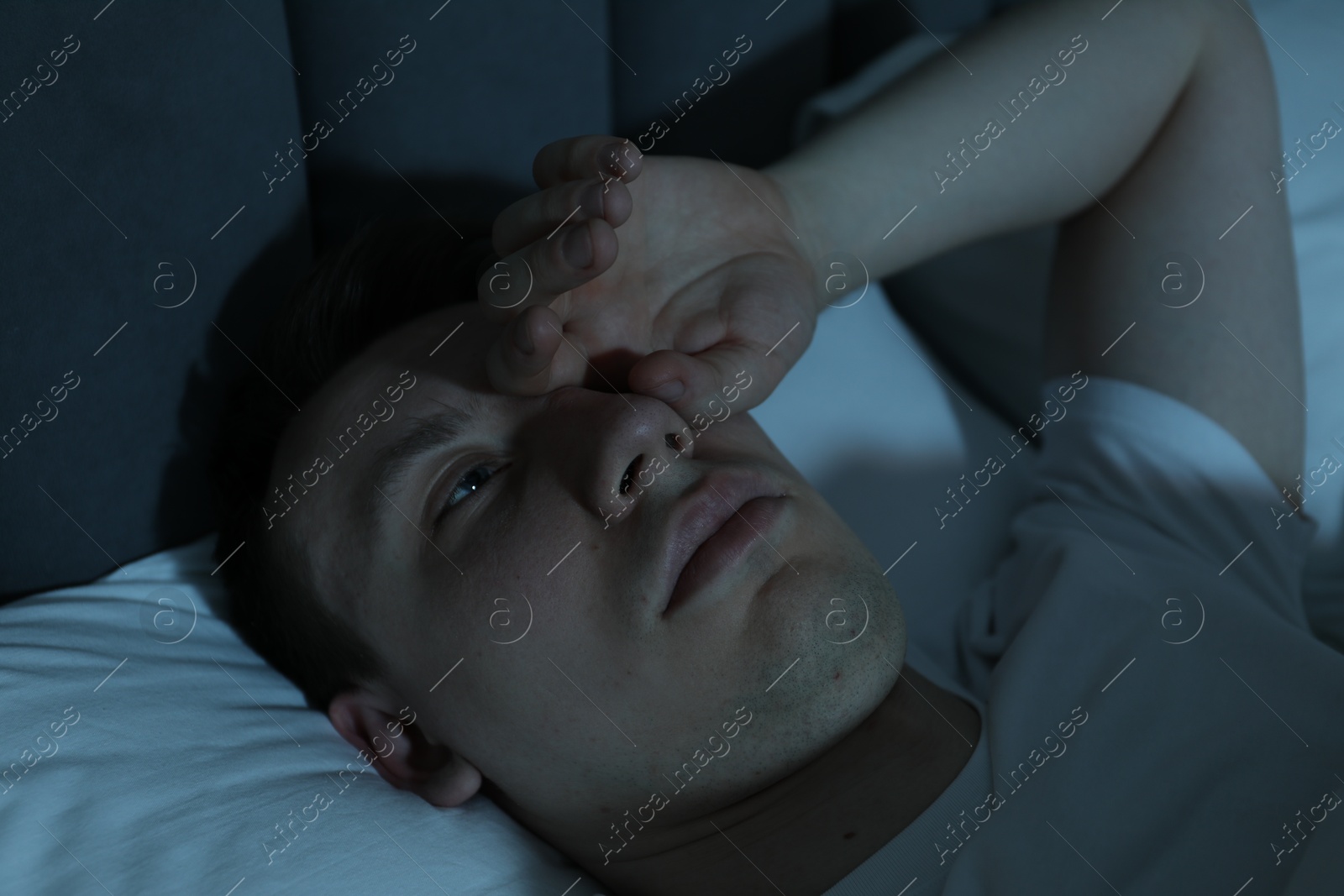 Frustrated man suffering from insomnia in bed indoors Photo of Frustrated man suffering from insomnia in bed indoors