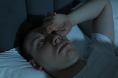 Photo of Frustrated man suffering from insomnia in bed indoors