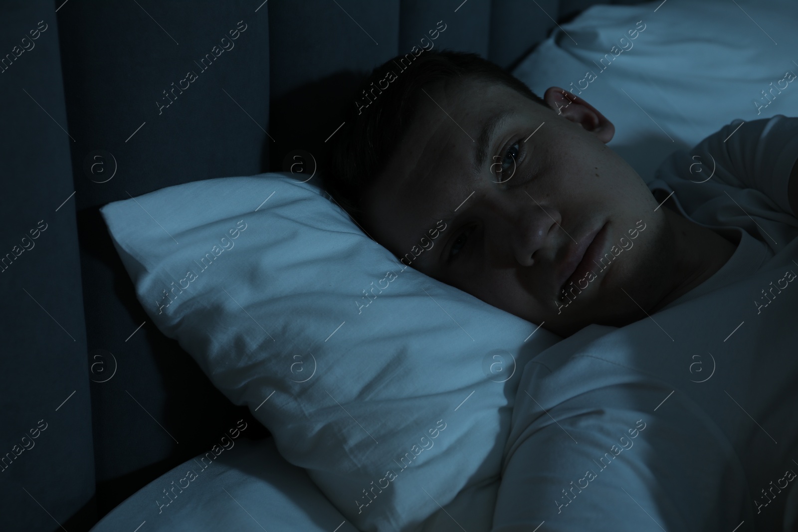 Photo of Frustrated man suffering from insomnia in bed indoors