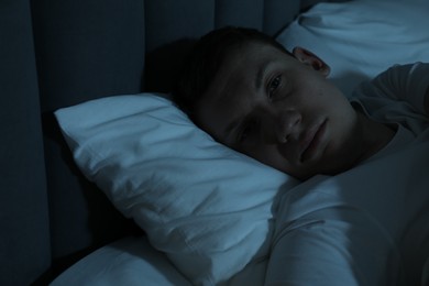 Photo of Frustrated man suffering from insomnia in bed indoors