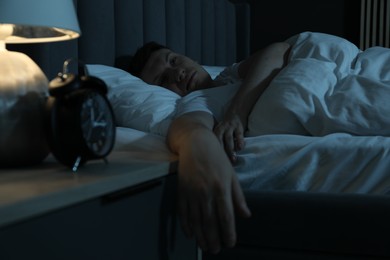 Photo of Frustrated man suffering from insomnia in bed indoors