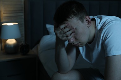 Photo of Frustrated man suffering from insomnia on bed indoors, space for text