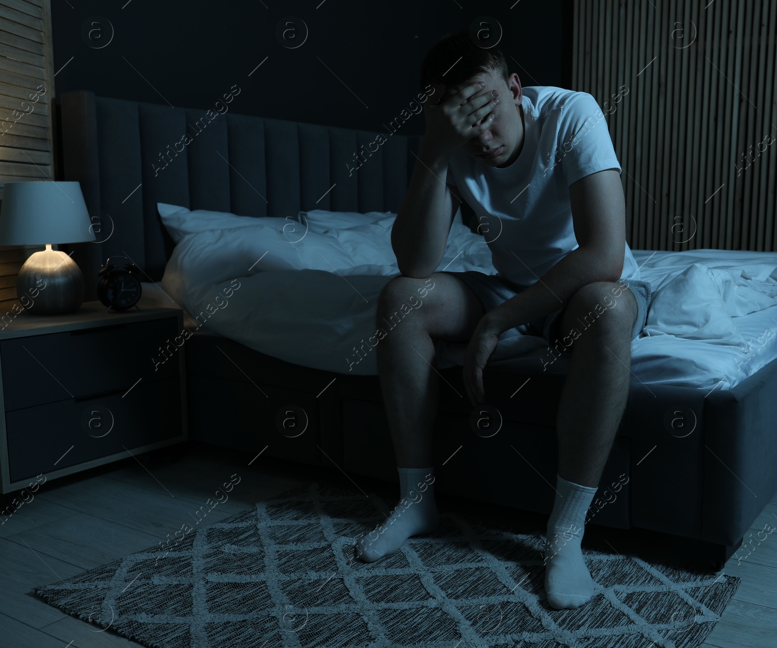 Frustrated man suffering from insomnia on bed indoors Photo of Frustrated man suffering from insomnia on bed indoors