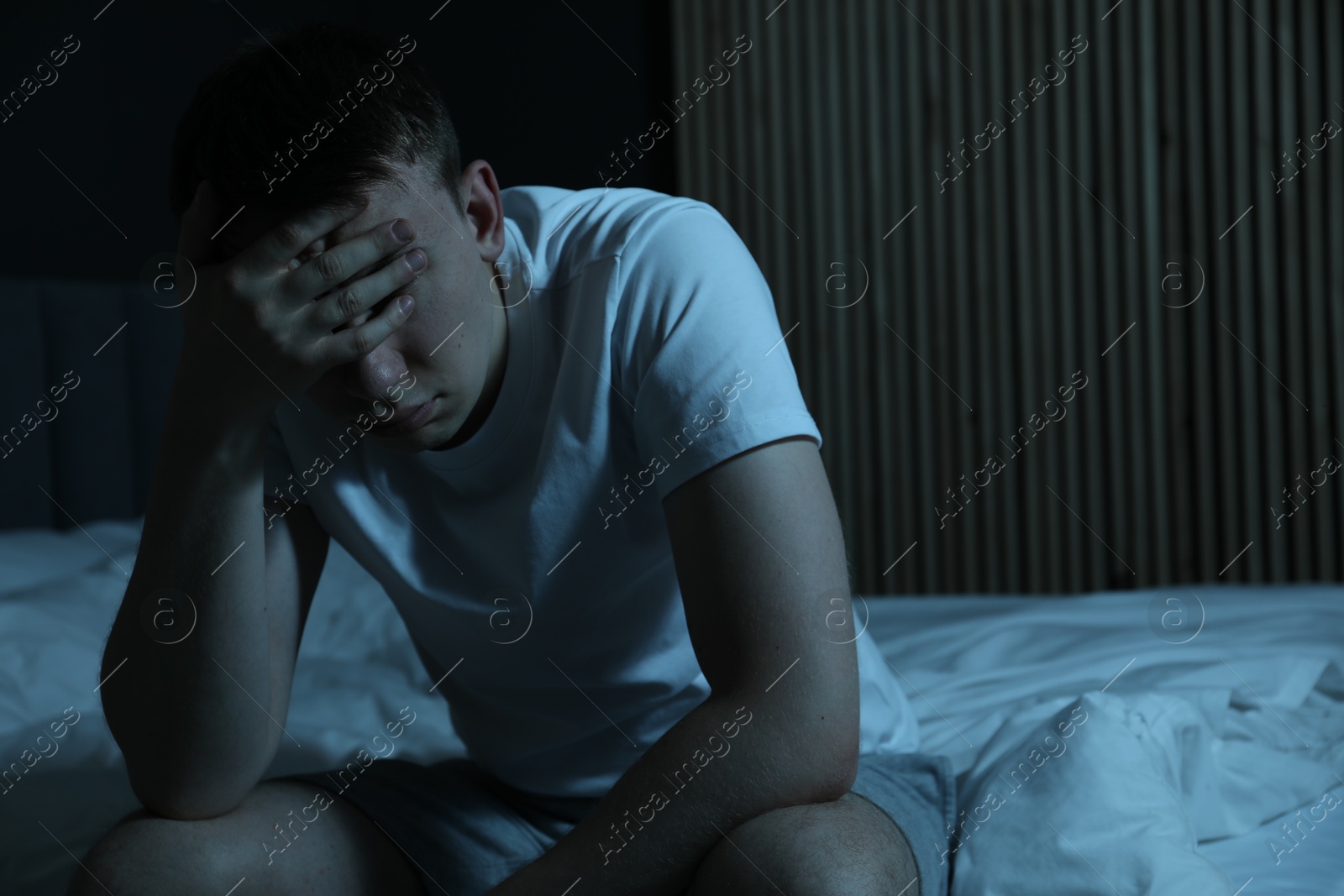 Photo of Frustrated man suffering from insomnia on bed indoors, space for text