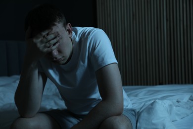 Photo of Frustrated man suffering from insomnia on bed indoors, space for text