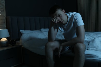Photo of Frustrated man suffering from insomnia on bed indoors, space for text