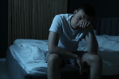 Photo of Frustrated man suffering from insomnia on bed indoors, space for text