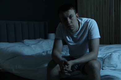 Photo of Frustrated man suffering from insomnia on bed indoors, space for text