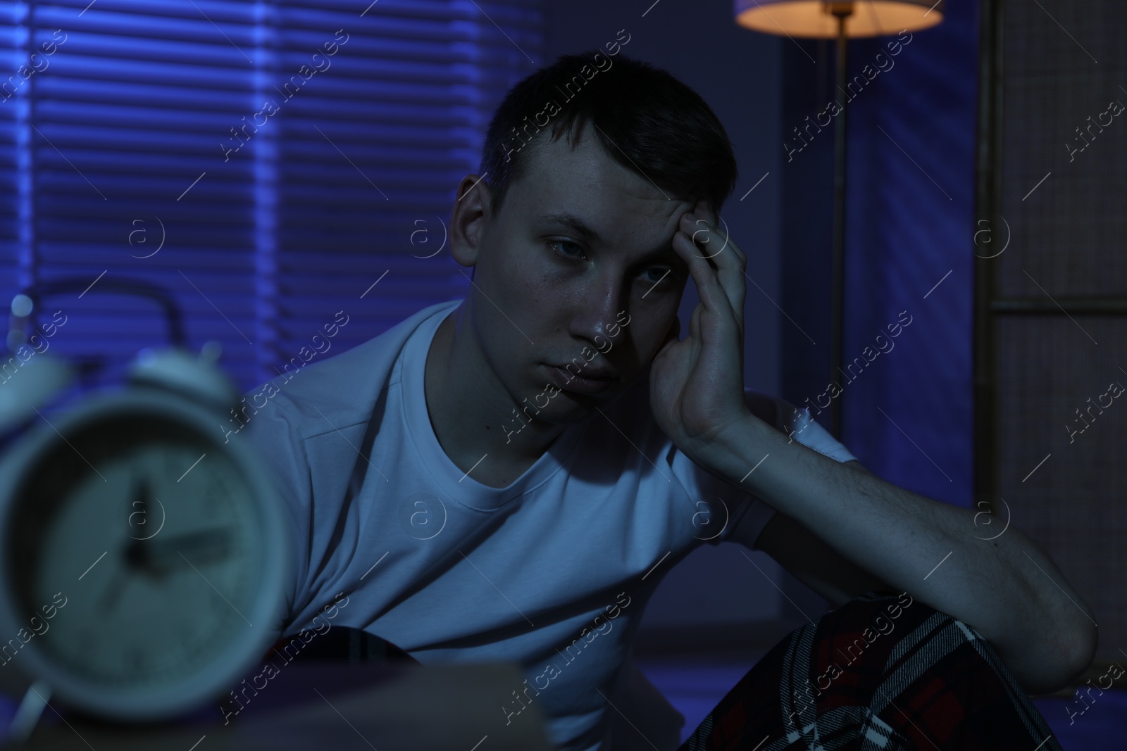 Photo of Frustrated man suffering from insomnia on floor indoors
