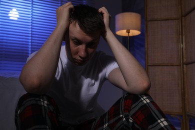 Photo of Frustrated man suffering from insomnia on floor indoors