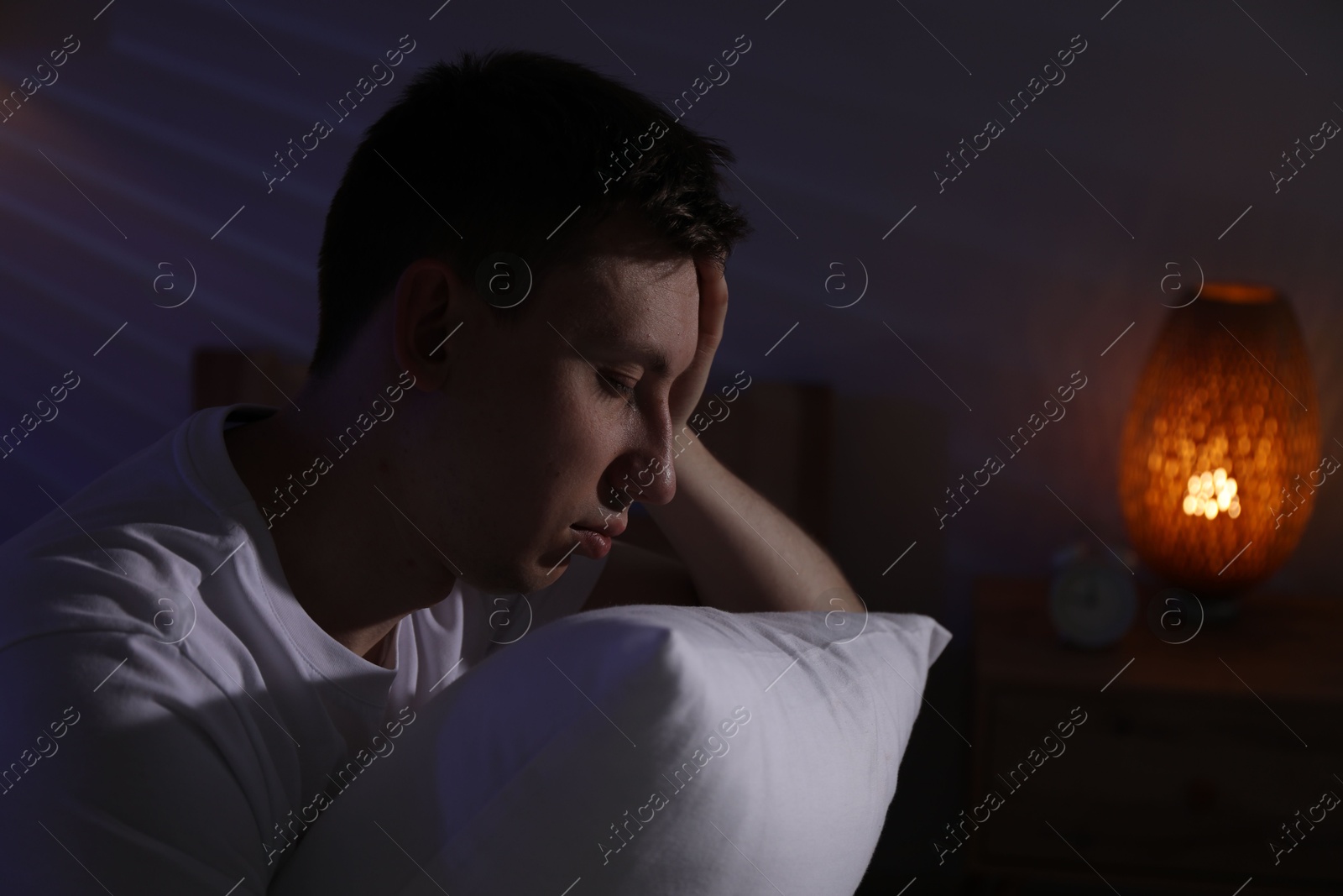 Frustrated man with pillow suffering from insomnia indoors, space for text Photo of Frustrated man with pillow suffering from insomnia indoors, space for text