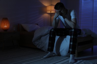 Photo of Frustrated man suffering from insomnia on bed indoors