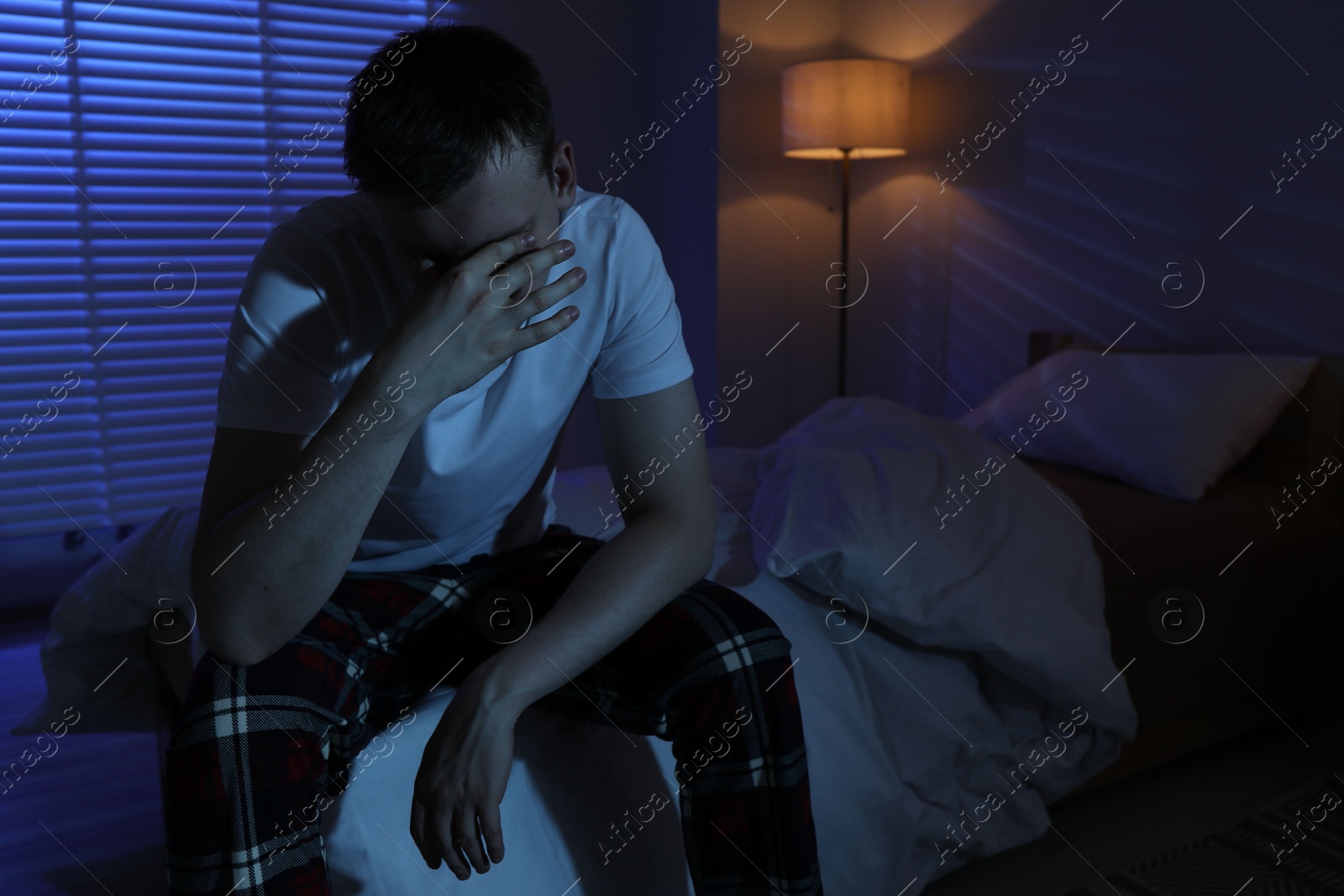 Frustrated man suffering from insomnia on bed indoors Photo of Frustrated man suffering from insomnia on bed indoors