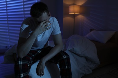 Photo of Frustrated man suffering from insomnia on bed indoors