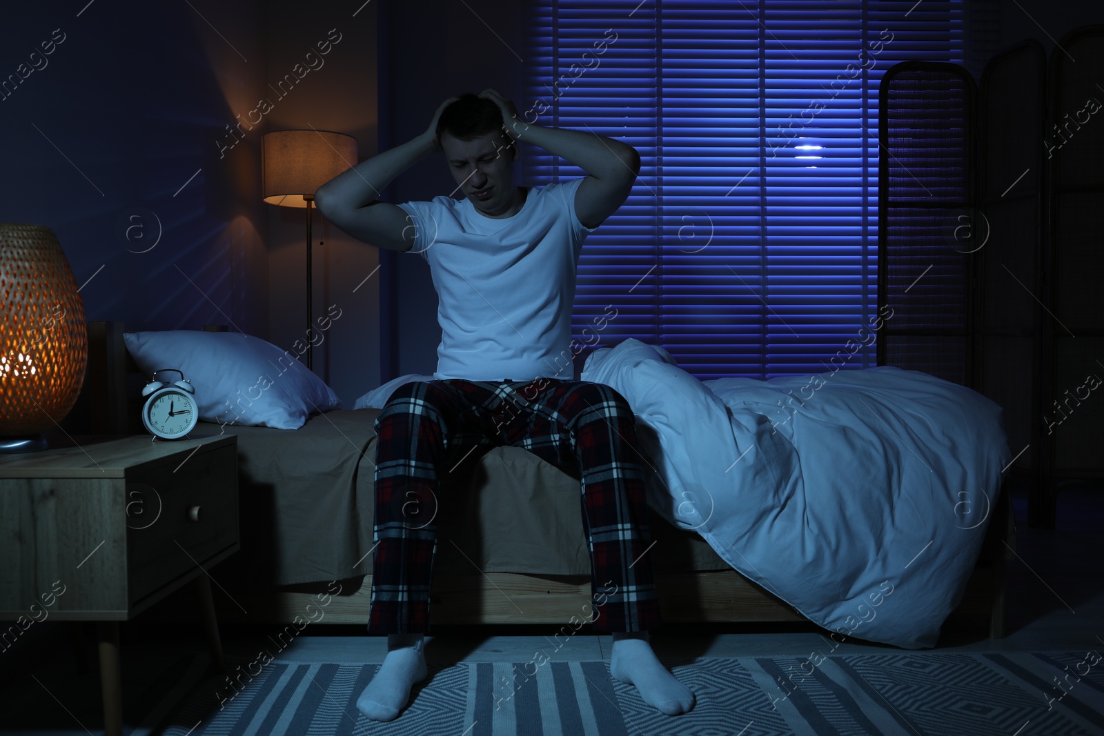 Frustrated man suffering from insomnia on bed indoors Photo of Frustrated man suffering from insomnia on bed indoors