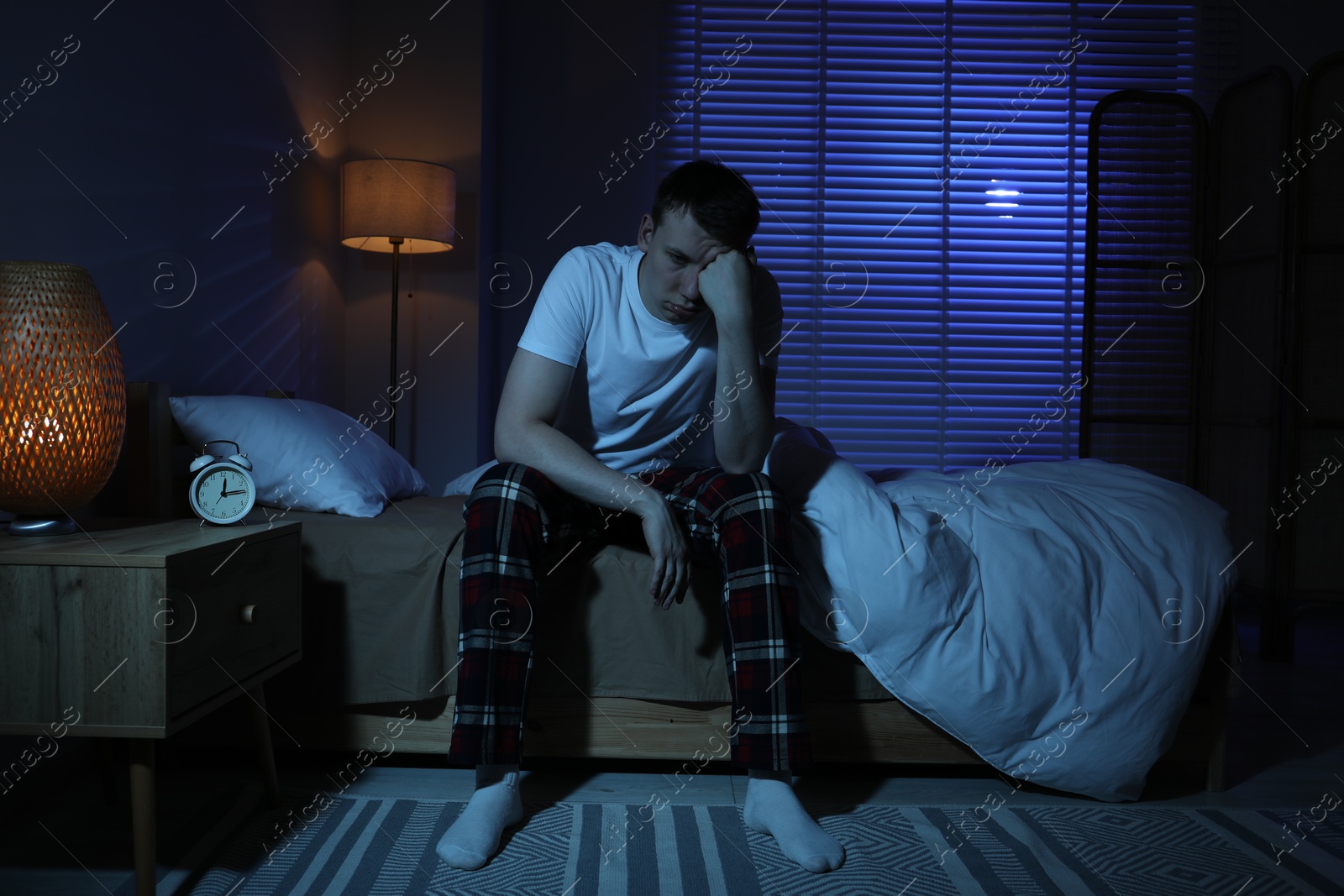 Photo of Frustrated man suffering from insomnia on bed indoors