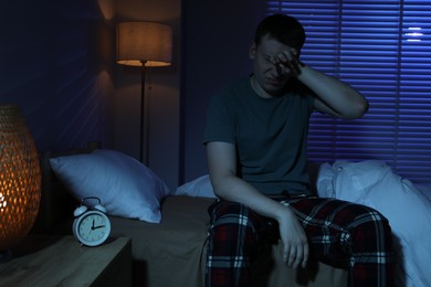 Photo of Frustrated man suffering from insomnia on bed indoors