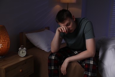 Photo of Frustrated man suffering from insomnia on bed indoors
