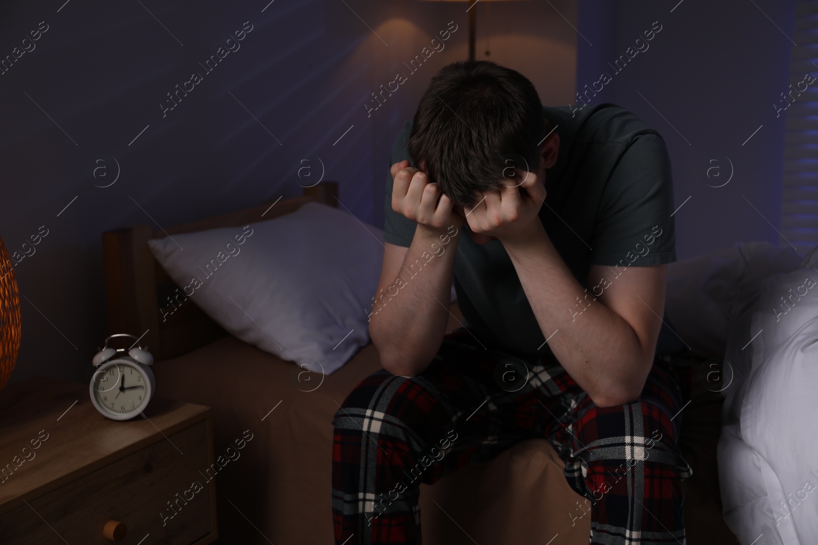 Photo of Frustrated man suffering from insomnia on bed indoors