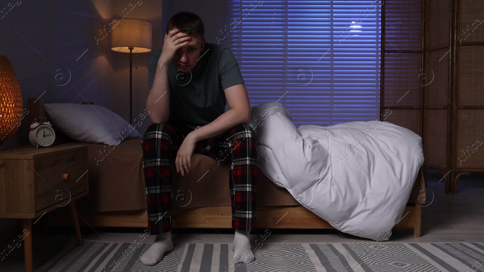 Frustrated man suffering from insomnia on bed indoors Photo of Frustrated man suffering from insomnia on bed indoors